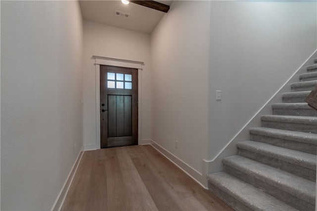 foyer entrance featuring light wood-style floors, stairs, and baseboards