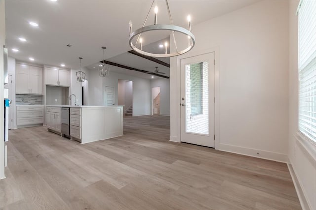 kitchen with light wood-type flooring, baseboards, open floor plan, pendant lighting, and white cabinets