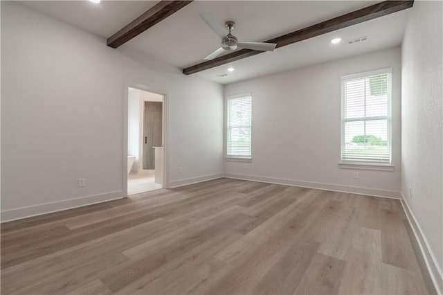 spare room featuring healthy amount of natural light, beamed ceiling, ceiling fan, light wood finished floors, and baseboards