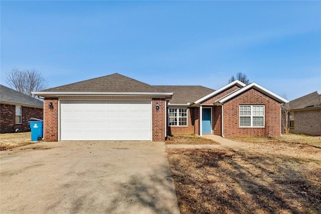 ranch-style home with a garage, roof with shingles, brick siding, and concrete driveway