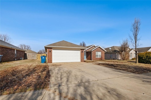 ranch-style home with a garage, brick siding, driveway, and fence