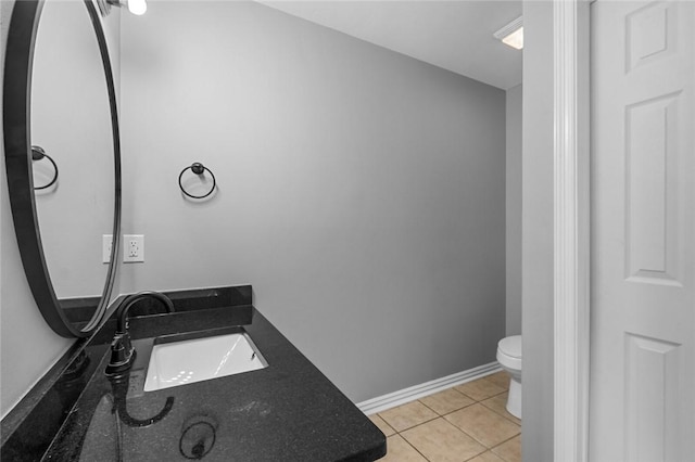 bathroom featuring toilet, tile patterned floors, vanity, and baseboards