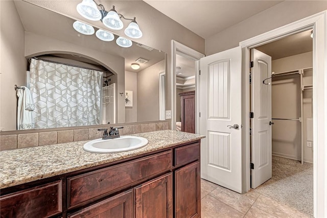 3207 SW Stonepoint Ave, Bentonville, AR 72712 - full bath featuring visible vents, curtained shower, a spacious closet, vanity, and tile patterned flooring