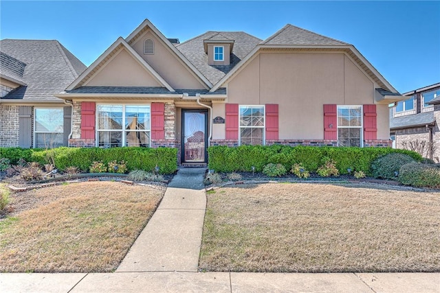 3207 SW Stonepoint Ave, Bentonville, AR 72712 - view of front of house with roof with shingles, stucco siding, stone siding, and a front lawn
