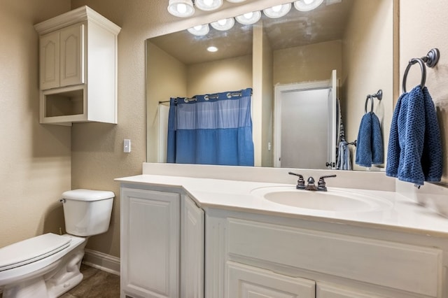 full bath featuring toilet, vanity, a textured wall, a shower with shower curtain, and baseboards