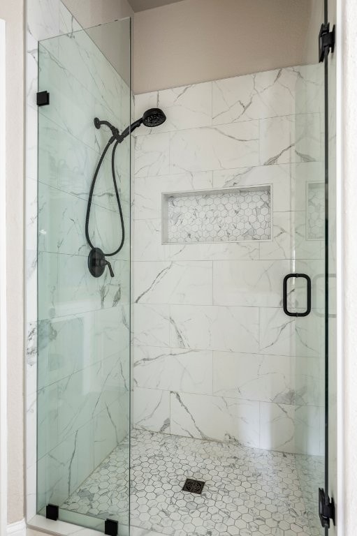 bathroom featuring a marble finish shower