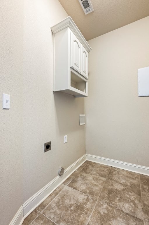 laundry room featuring hookup for an electric dryer, baseboards, and cabinet space