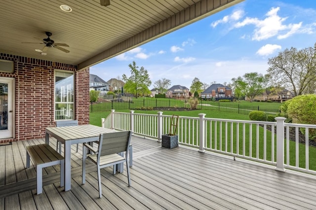 wooden terrace with a ceiling fan, outdoor dining area, and a residential view