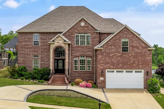 view of front of house with brick siding, roof with shingles, a garage, and driveway