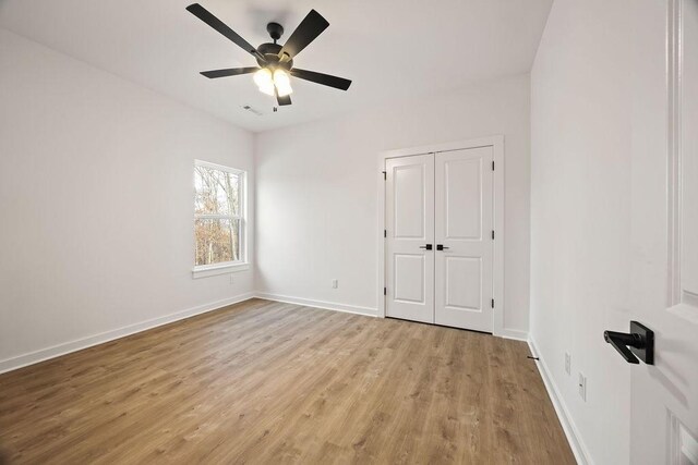 5 Kirkstile Ln, Bella Vista, AR 72715 - unfurnished bedroom featuring a closet, light wood finished floors, baseboards, and a ceiling fan