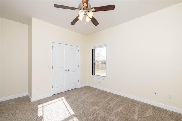 unfurnished bedroom with a closet, ceiling fan, baseboards, and carpet