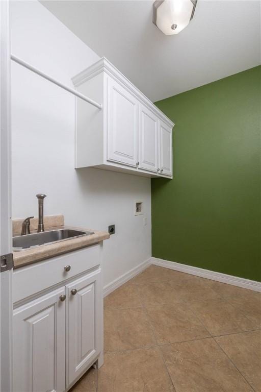 clothes washing area featuring baseboards, a sink, hookup for an electric dryer, cabinet space, and hookup for a washing machine