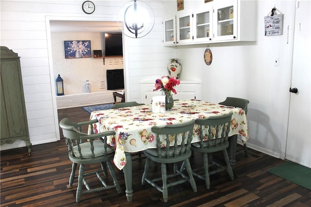 701 Crossbow Rd, Huntsville, AR 72740 - dining area featuring dark wood-type flooring, wood walls, baseboards, and a chandelier