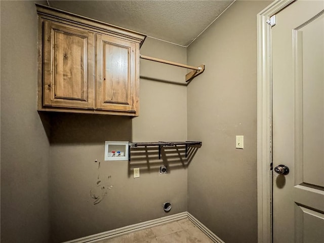 laundry room featuring cabinet space, a textured ceiling, hookup for a washing machine, and baseboards