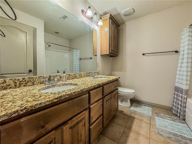 bathroom featuring toilet, double vanity, a sink, and visible vents