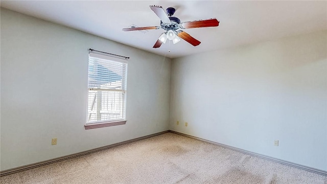 spare room featuring light carpet, baseboards, and a ceiling fan