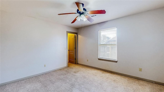 spare room featuring ceiling fan, carpet floors, visible vents, and baseboards