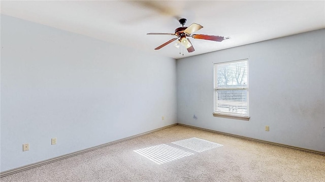 carpeted spare room with a ceiling fan