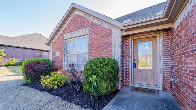 view of exterior entry featuring brick siding