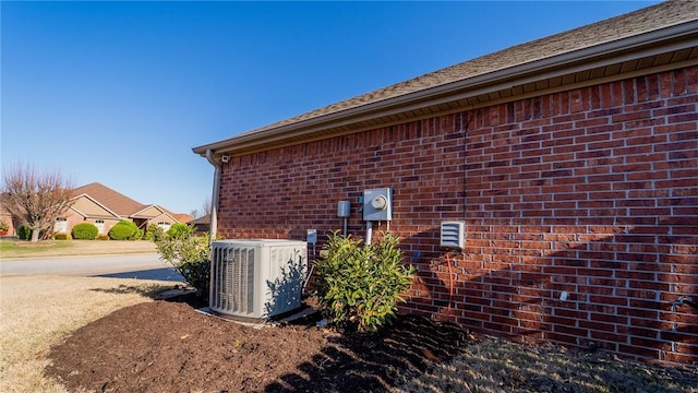view of property exterior with brick siding and central AC unit