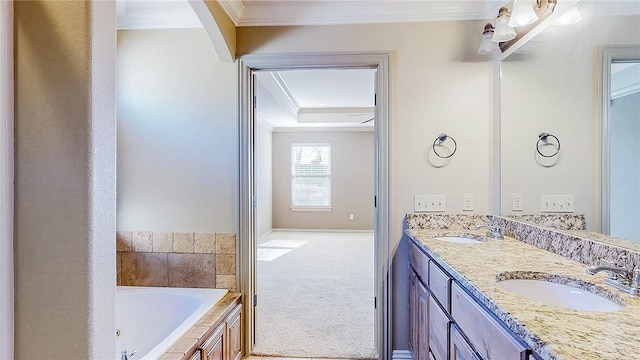 full bathroom with a raised ceiling, a tub with jets, ornamental molding, and a sink