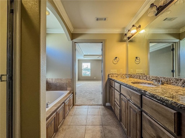 bathroom featuring a bath, crown molding, a sink, and visible vents