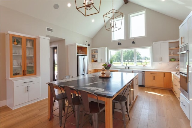 kitchen with a chandelier, visible vents, open shelves, and appliances with stainless steel finishes