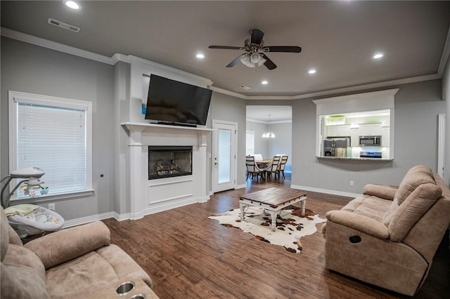 living area featuring baseboards, recessed lighting, a ceiling fan, visible vents, and wood finished floors
