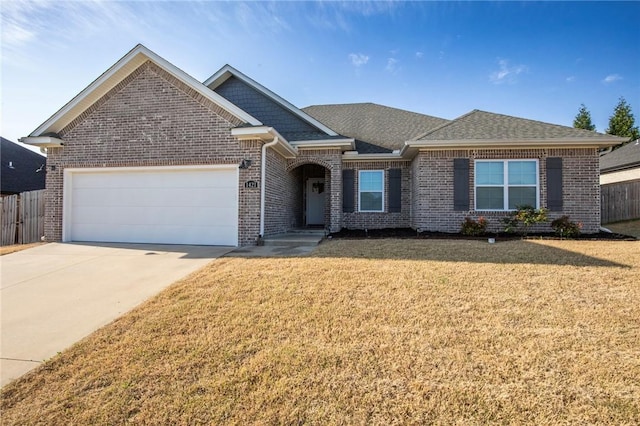 view of front of home featuring a front yard, an attached garage, fence, concrete driveway, and brick siding