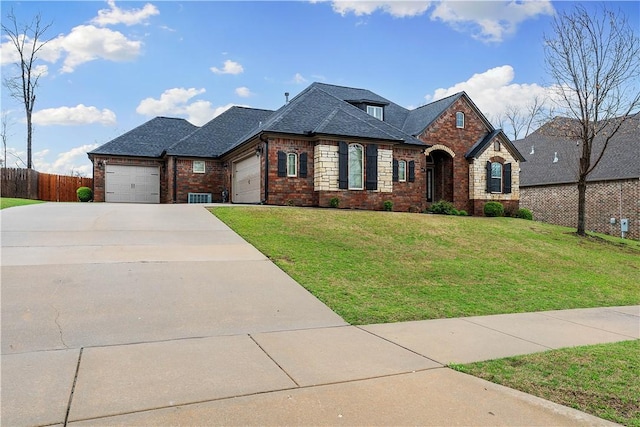 french provincial home with an attached garage, fence, concrete driveway, brick siding, and a front lawn