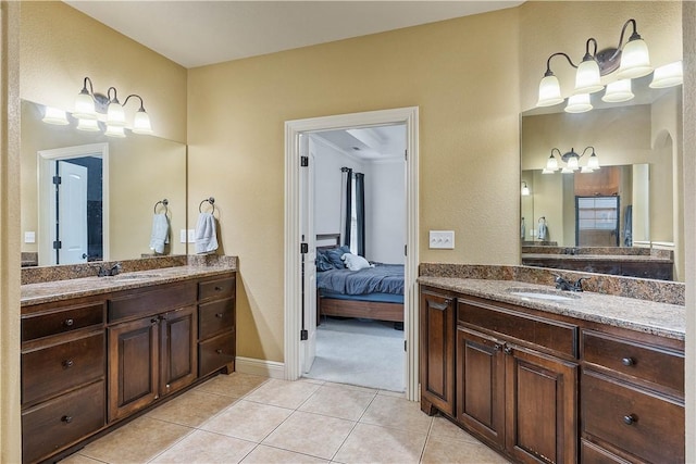 full bath with a sink, tile patterned floors, two vanities, and a chandelier