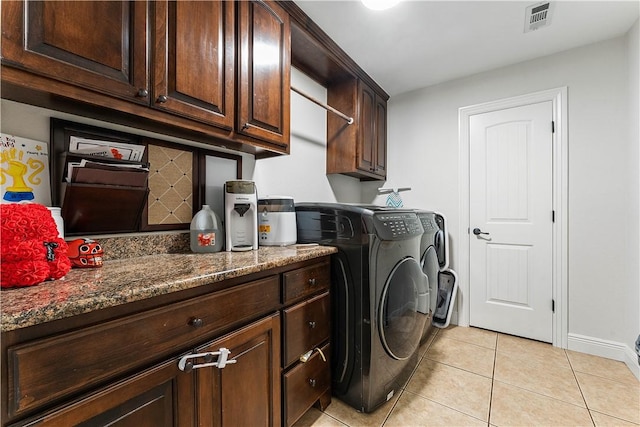 clothes washing area with light tile patterned floors, independent washer and dryer, visible vents, baseboards, and cabinet space