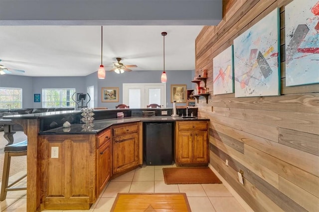 1402 NE Fairwinds Dr, Bentonville, AR 72712 - kitchen featuring a kitchen breakfast bar, a ceiling fan, dark countertops, open floor plan, and brown cabinets