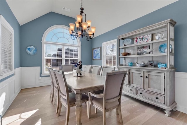 1402 NE Fairwinds Dr, Bentonville, AR 72712 - dining area with a notable chandelier, vaulted ceiling, visible vents, wainscoting, and a decorative wall