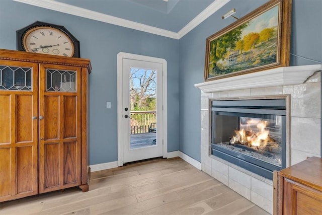 1402 NE Fairwinds Dr, Bentonville, AR 72712 - doorway to outside with crown molding, baseboards, light wood-type flooring, and a tiled fireplace
