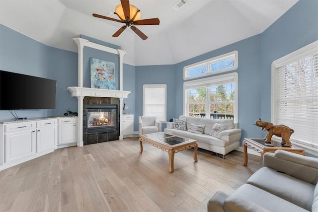 1402 NE Fairwinds Dr, Bentonville, AR 72712 - living area with light wood-style floors, ceiling fan, a tiled fireplace, and visible vents