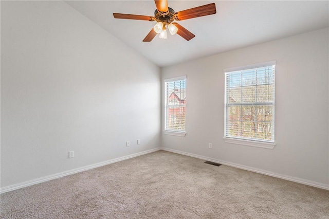 spare room with a ceiling fan, visible vents, carpet floors, lofted ceiling, and baseboards