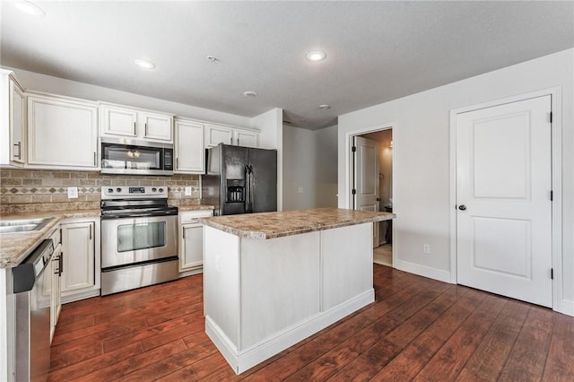 kitchen with backsplash, dark wood-style floors, a kitchen island, and stainless steel appliances
