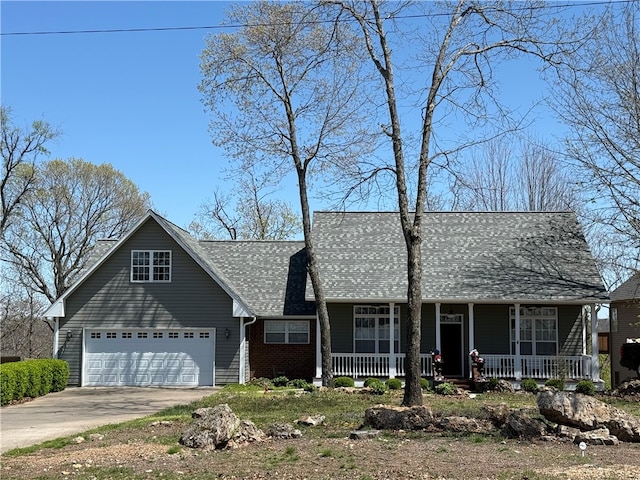 view of front of home with brick siding, driveway, and covered porch