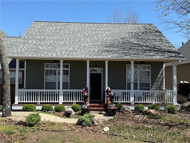 view of front of house with a shingled roof, ceiling fan, and covered porch