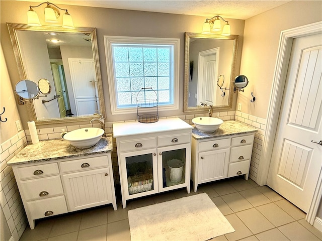 bathroom with two vanities, tile patterned flooring, and a sink