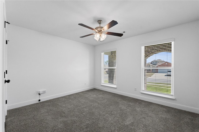 6011 NW Hoover St, Bentonville, AR 72713 - spare room with baseboards, a ceiling fan, and dark colored carpet