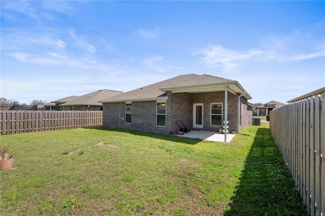 6011 NW Hoover St, Bentonville, AR 72713 - back of property with a yard, brick siding, a fenced backyard, and a patio