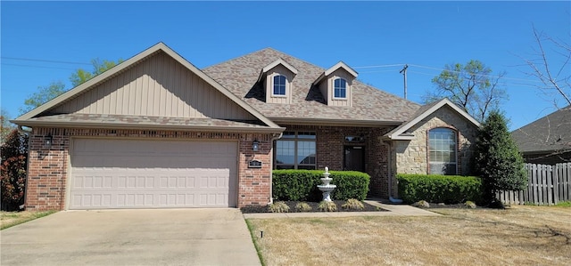 view of front facade with a garage, fence, brick siding, a shingled roof, and driveway