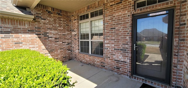 view of exterior entry with brick siding