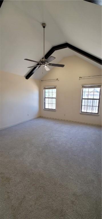 empty room featuring carpet flooring, baseboards, a ceiling fan, and lofted ceiling