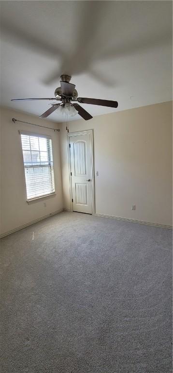 empty room with ceiling fan and baseboards