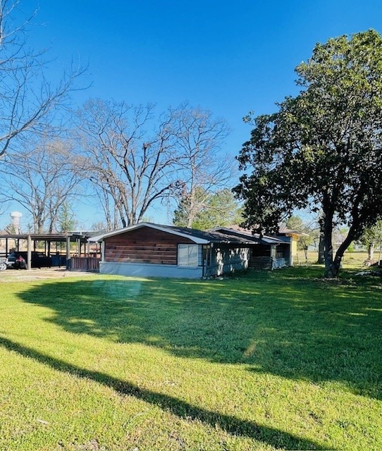 exterior space featuring a yard and a carport