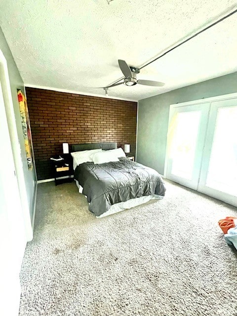 1110 NW 7th St, Bentonville, AR 72712 - bedroom with carpet flooring, a textured ceiling, brick wall, a ceiling fan, and access to outside