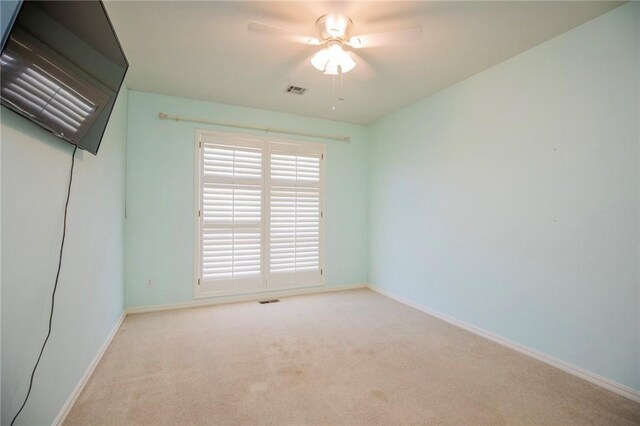 carpeted empty room with ceiling fan, baseboards, and visible vents